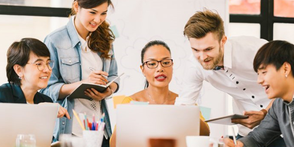 office workers gathered around laptop