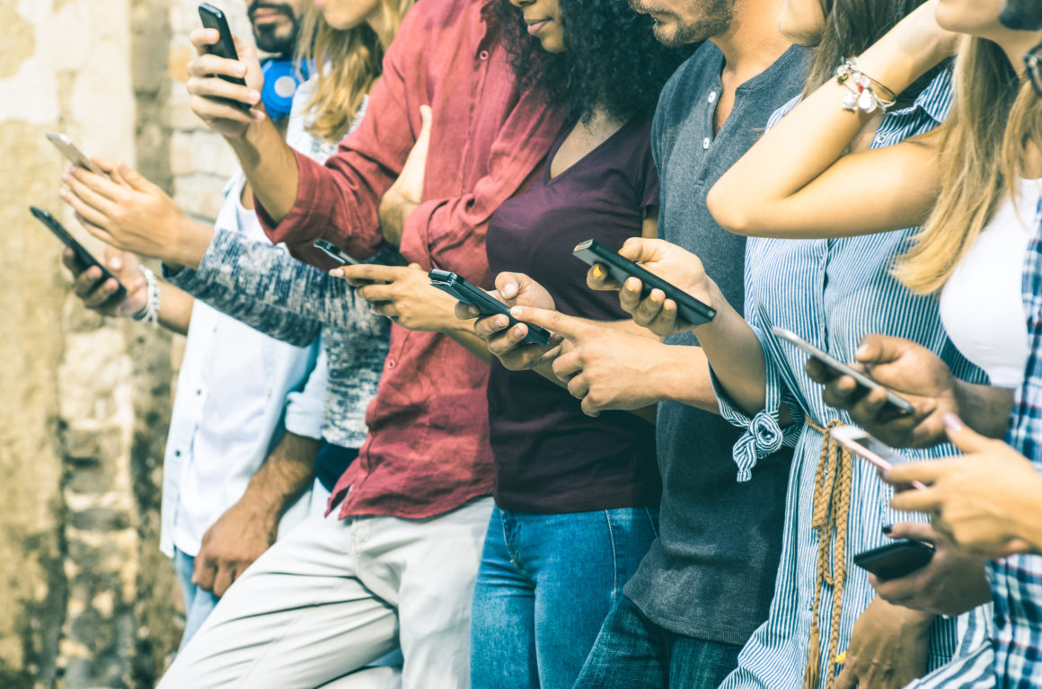 row of people using mobile phones